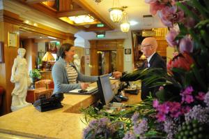 a man and a woman standing at a counter at Park House Hotel in Galway