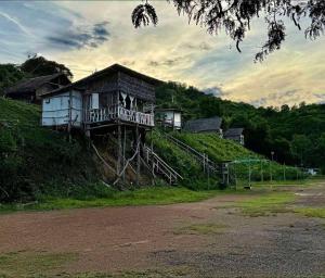 a building on top of a hill with a house at Homestay with Rive View Bann Good View in Ban Hua Phrong