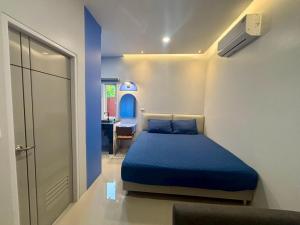 a bedroom with a blue bed and a desk at Tiny house bangtao phuket in Ban Thalat Choeng Thale