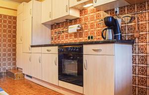 a kitchen with white cabinets and a black oven at Beautiful Apartment In Reifferscheid in Reifferscheid