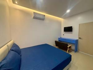 a bedroom with a blue bed and a desk at Tiny house bangtao phuket in Ban Thalat Choeng Thale