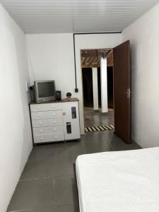 a room with a bed and a tv on a dresser at Pesqueiro & Pousada Beatriz in Piedade