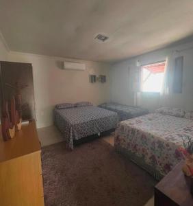 a bedroom with two beds and a window at Casa temporada frances in Marechal Deodoro +21 photos
