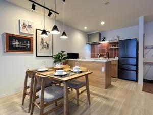 a kitchen and dining room with a table and chairs at Akayane Lodge by H2 Life in Nakafurano