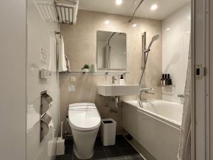 a bathroom with a toilet and a sink and a tub at Akayane Lodge by H2 Life in Nakafurano +11 photos