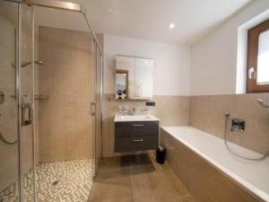 a bathroom with a shower and a sink and a tub at Luxury alpine chalet in Neukirchen in Neukirchen am Großvenediger +41 photos