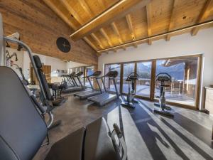 a gym with a row of tread machines in a room at Luxury alpine chalet in Neukirchen in Neukirchen am Großvenediger