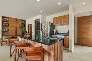 a kitchen with wooden cabinets and a counter top at Akumal Cielo Seven Ocean View Pools Beach Access in Akumal