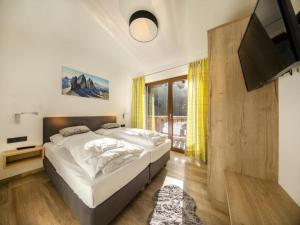 a bedroom with a large bed and a television at Luxury alpine chalet in Neukirchen in Neukirchen am Großvenediger