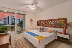 a bedroom with a bed and a ceiling fan at Akumal Cielo Seven Ocean View Pools Beach Access in Akumal