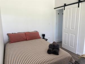 a bedroom with a bed with a teddy bear on it at Hanger Ridge Cabin in Goodger +4 photos