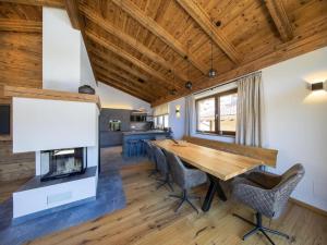 a dining room with a wooden table and a fireplace at Chalet with sauna, Neukirchen in Neukirchen am Großvenediger