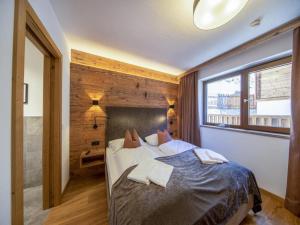 a bedroom with a bed and a large window at Chalet with sauna, Neukirchen in Neukirchen am Großvenediger
