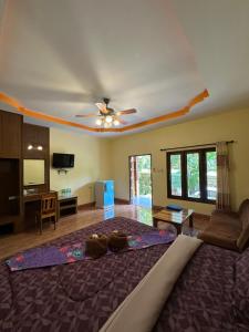 a living room with a couch and a ceiling fan at Phu Lanta Life Resort in Ko Lanta