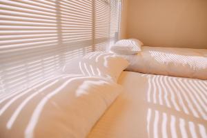 a bedroom with a bed and a window with blinds at OneStay一宿 無料駐車場 駅徒歩2分 和モダン一軒家 小庭付き 静か お子様連れに優しい 名古屋駅近 in Nagoya