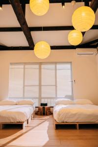 three beds in a room with three lights at OneStay一宿 無料駐車場 駅徒歩2分 和モダン一軒家 小庭付き 静か お子様連れに優しい 名古屋駅近 in Nagoya