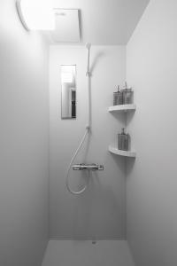 a white bathroom with a sink and a mirror at The KAMUY FURANO in Nakafurano