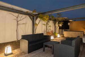a patio with two couches and a table and lights at Bijou Suites AI PREMIUM in Osaka