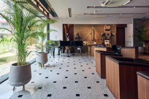 a lobby with two potted plants and a piano at Hotel Lexton Kagoshima in Kagoshima +82 photos
