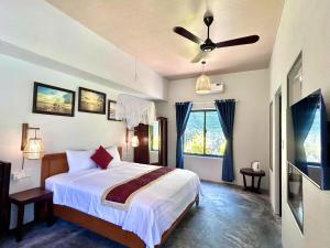 a bedroom with a bed and a ceiling fan at Ocean House An Bang in Hoi An