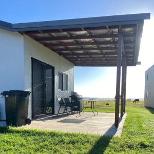 a patio with awning and a table in a field at Hanger Ridge Cabin in Goodger