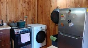 a kitchen with a refrigerator and a stove at Casa cerca de lago Caburgua in Pucón