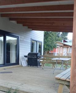 a patio with a grill and a picnic table at Casa cerca de lago Caburgua in Pucón