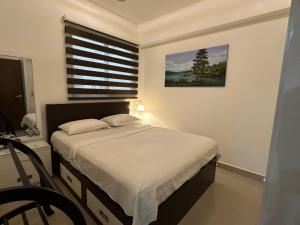 a bedroom with a bed with a window and a chair at Oval View Residencies By C in Colombo +7 photos