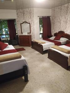 a large bedroom with two beds and a mirror at Hotel Ejecutivo in Pereira