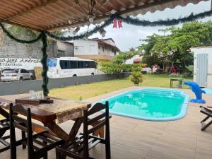 a swimming pool with a table and a picnic table and a bus at AP mobiliado em Guaibim in Guaibim