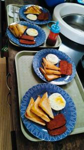 four blue plates of breakfast foods on a counter at Sea La Vie Cottage in El Nido +37 photos
