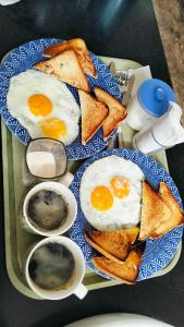 a plate of eggs and toast on a table at Sea La Vie Cottage in El Nido