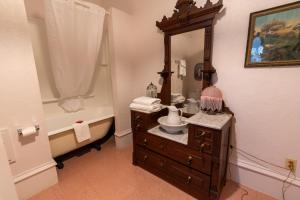 a bathroom with a sink and a mirror and a tub at Jackson House Hotel in Eureka