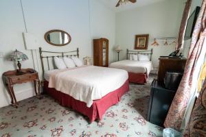 a bedroom with two beds and a mirror at Jackson House Hotel in Eureka +25 photos