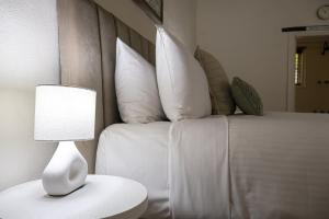a bedroom with a bed with white pillows and a lamp at Kaesler Cottages in Nuriootpa