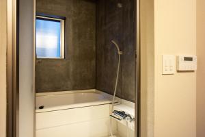 a bathroom with a bath tub and a window at SOUQ Renovated Townhouse in Himeji Quiet Market District in Himeji +22 photos