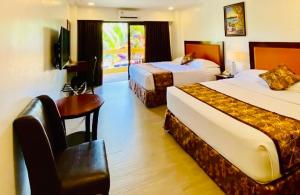 a hotel room with two beds and a desk at Paradise Station 3 Garden Boracay Resort by JustGoFun in Boracay +29 photos