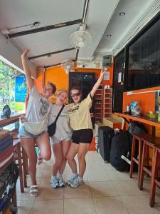 three people posing for a picture in front of a food truck at Voyagers Hostel in Phi Phi Islands