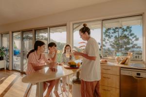 a woman standing in a kitchen with a group of people at Cloudbreak Currumbin in Gold Coast