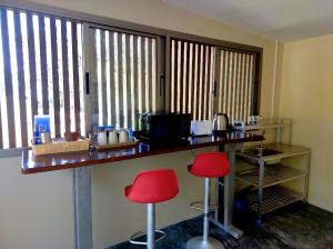 a bar with two red stools in a room with a window at Tha Khao Beach House 1 in Ban Bang Chak +29 photos