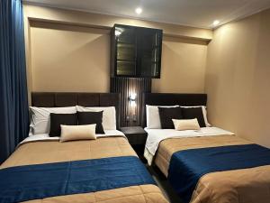 a bedroom with two beds and a cabinet at Gran Hotel in Yungay