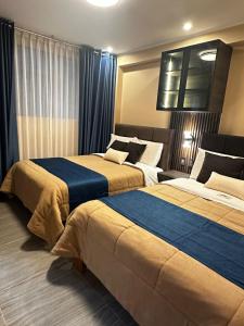 two beds sitting next to each other in a room at Gran Hotel in Yungay