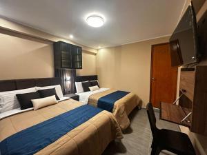 a hotel room with two beds and a flat screen tv at Gran Hotel in Yungay +25 photos