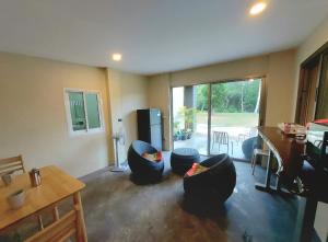 a living room with couches and a table and a kitchen at Tha Khao Beach House 1 in Ban Bang Chak