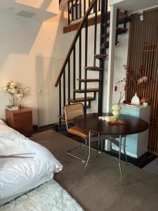 a bedroom with a table and a spiral staircase at Shanghai Historical Forest Cabin loft With Balcony at second floor near middle Huaihai road in Shanghai