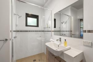 a white bathroom with a sink and a shower at Hartzell One Seven - Private - Family Friendly in Wilyabrup +23 photos