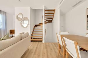 a living room with a dining room table and stairs at Salt Tugun in Gold Coast