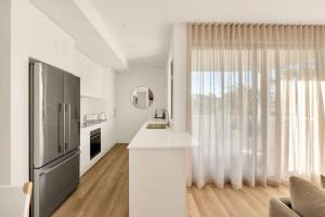 a kitchen with a large window and a refrigerator at Salt Tugun in Gold Coast +16 photos