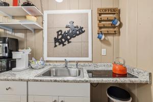 a kitchen with a sink and a coffee sign at Spacious comfortable Studio Unit in Tallahassee +9 photos