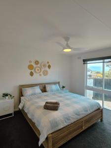 a bedroom with a large bed with a large window at Sitara Cottage in Yanakie